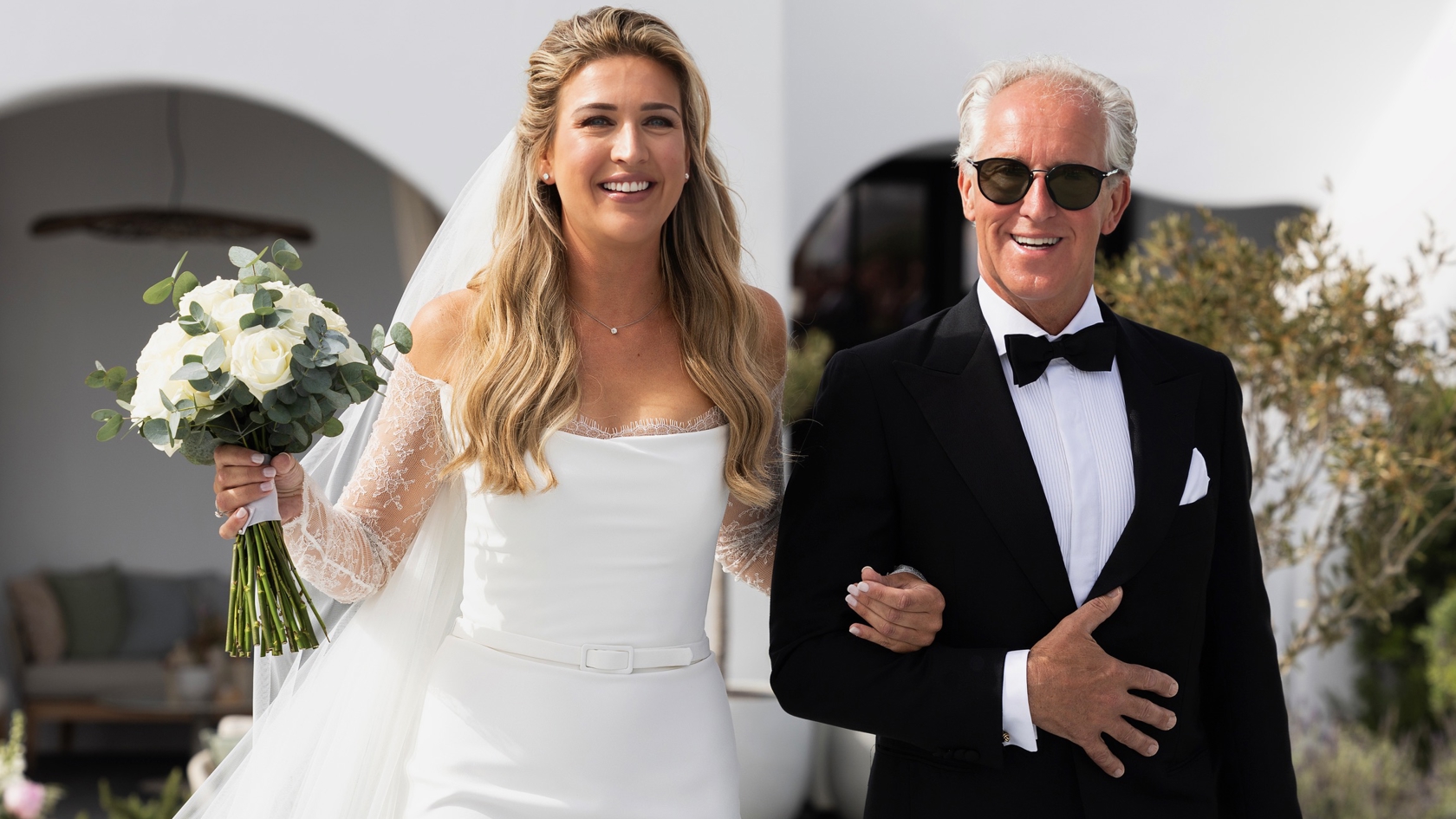 Bo Wilkes wordt naar het altaar begeleid door haar vader – emotioneel moment tijdens exclusieve destination wedding op Santorini
