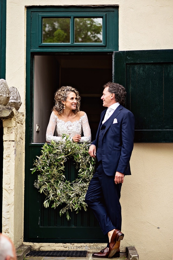 Steffie & Leonard kijken elkaar glimlachend aan in stijlvol landhuis – intiem moment tijdens hun luxe bruiloft, verzorgd door een high end weddingplanner