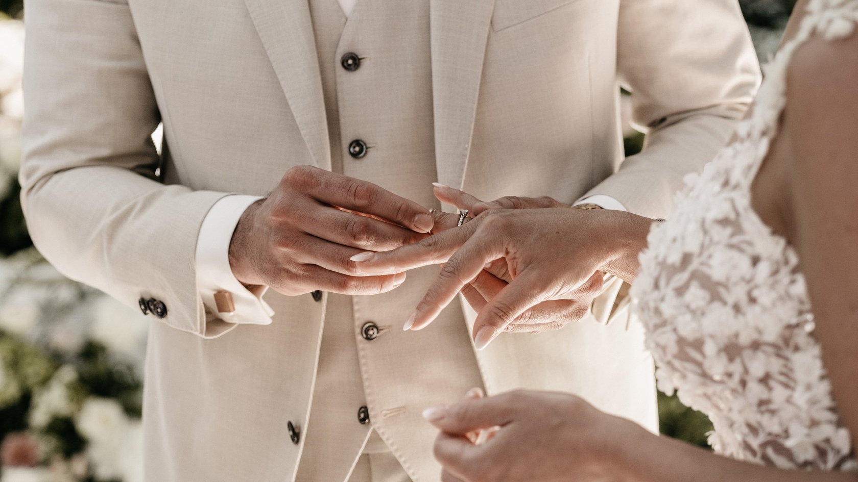 Bruidegom schuift trouwring om bij bruid tijdens een intiem moment van de bruiloft – georganiseerd door weddingplanner in Spanje