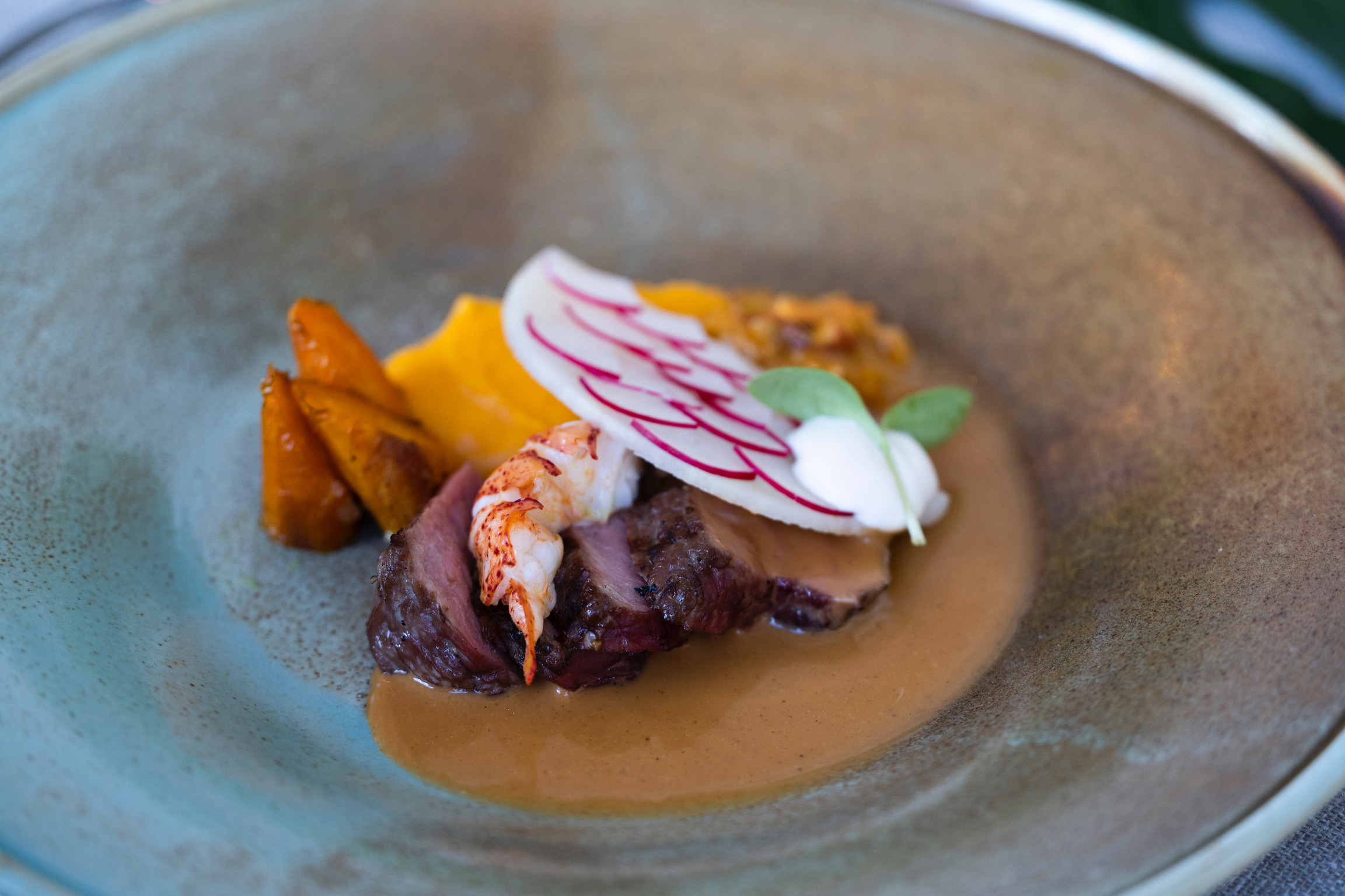 Close-up van feestelijk opgediende hertenbiefstuk met fijne garnering, perfect voor culinaire verwennerij tijdens exclusieve feesten.