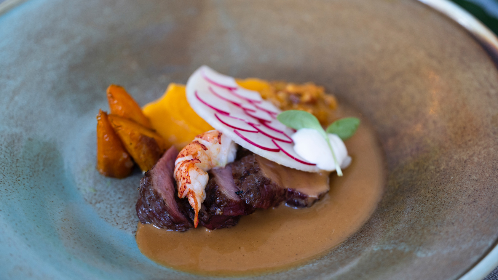 Close-up van feestelijk opgediende hertenbiefstuk met fijne garnering, perfect voor culinaire verwennerij tijdens exclusieve feesten.