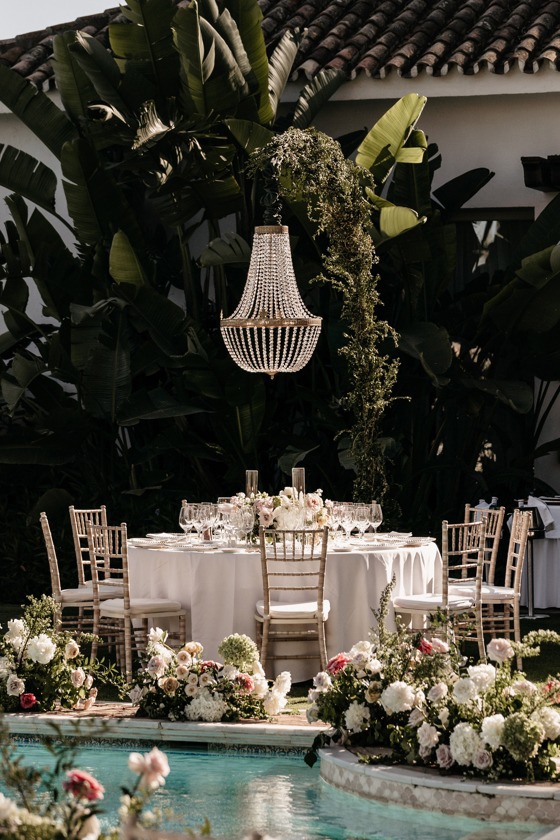 Kristallen kroonluchter boven een stijlvol gedekte tafel tijdens een bruiloft in Marbella – vastgelegd tussen 16 en 18 mei 2024