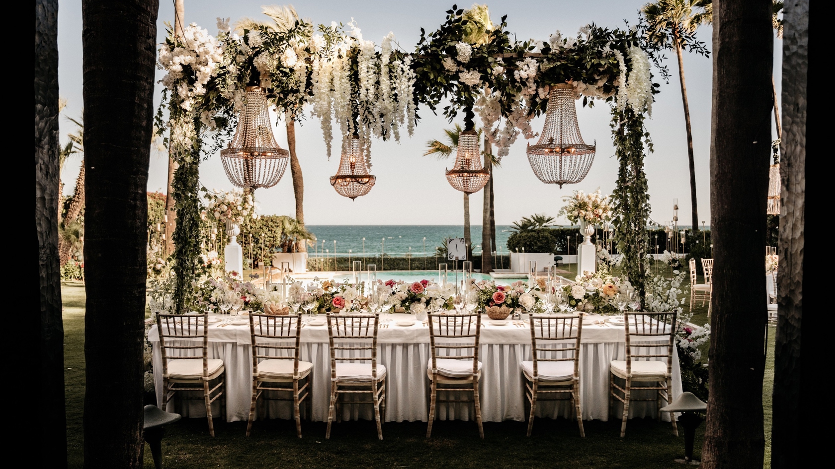 Luxe dinertafels bij Marbella Club Hotel – gouden stoelen en kroonluchter boven de tafel aan het zwembad, verzorgd door destination weddingplanner in Spanje